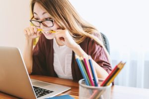 Woman Reading Screen Limiting Beliefs About Money