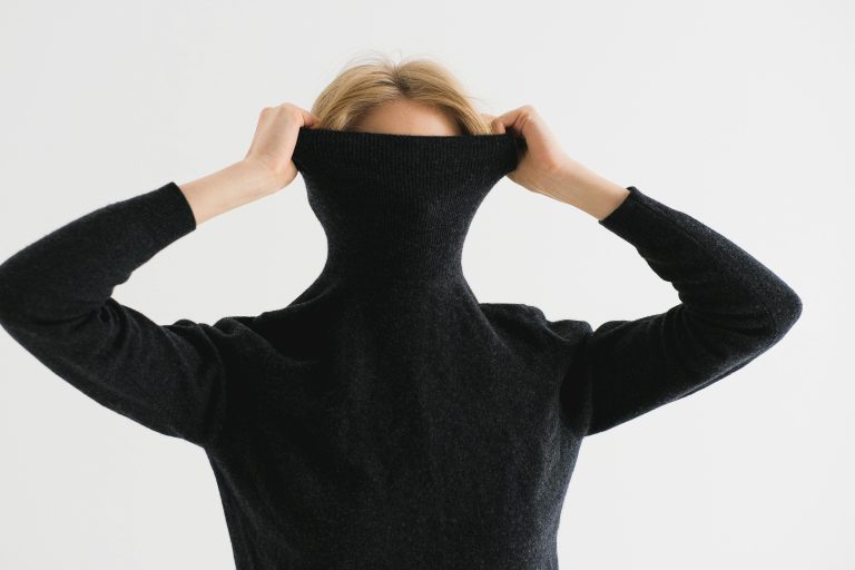Woman hiding under sweater