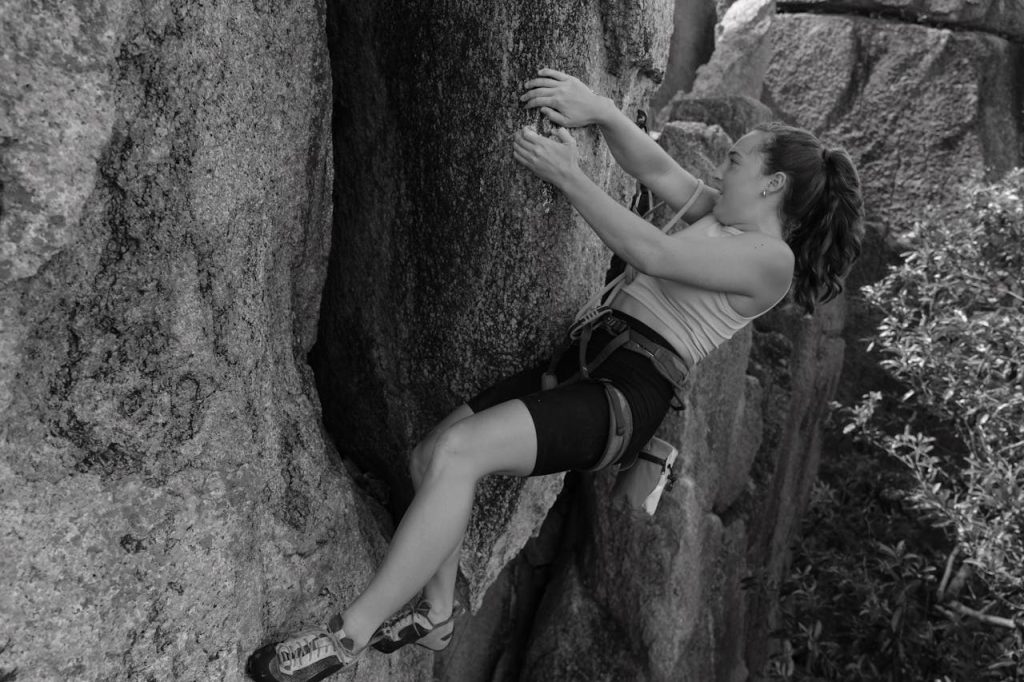 Woman climbs rocks with tenacity and persistence